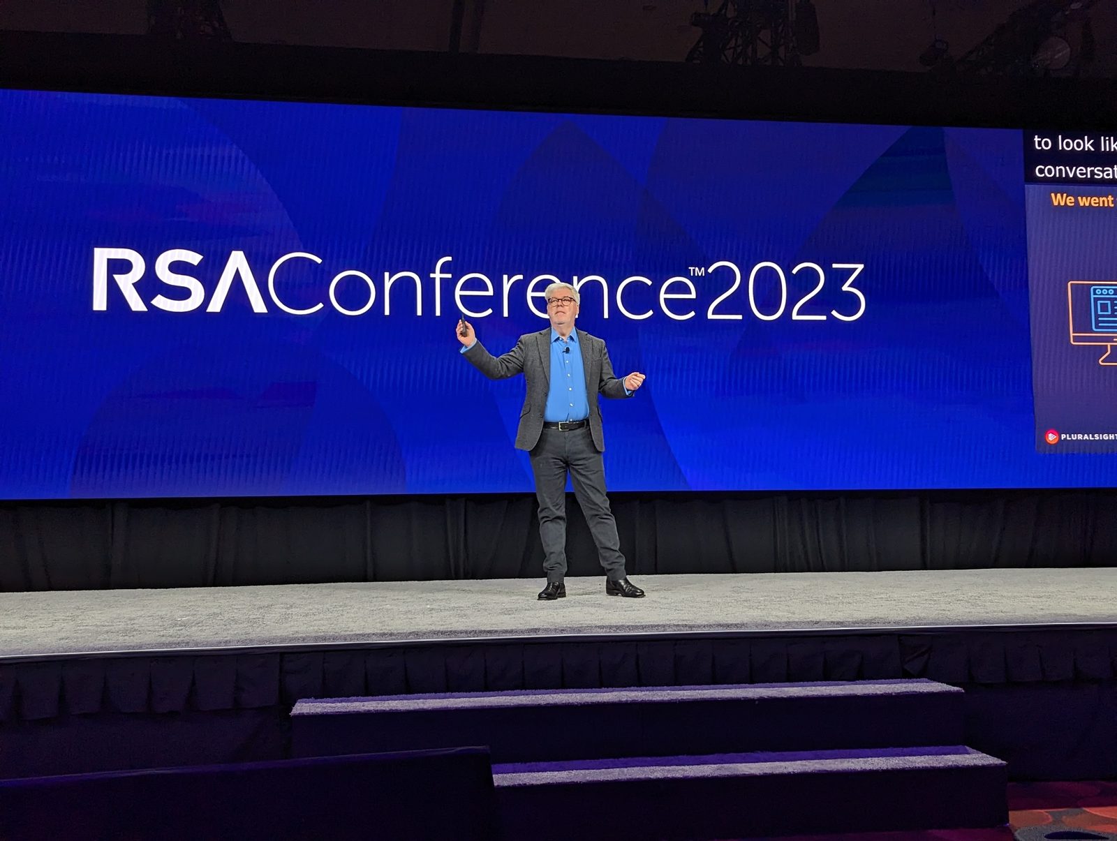 John Elliott on stage delivering a keynote in front of a large RSA Conference 2023 screen.